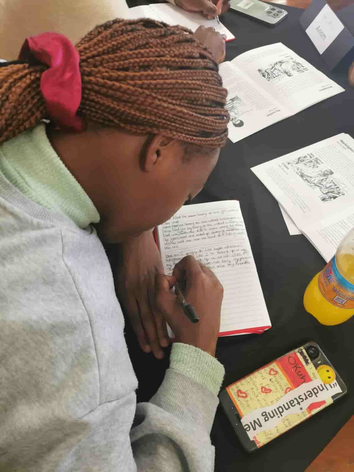 A young participant writing in a notebook